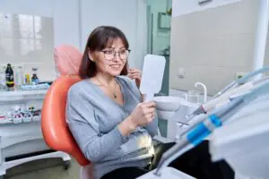 woman checking smile at dental office gum disease concept